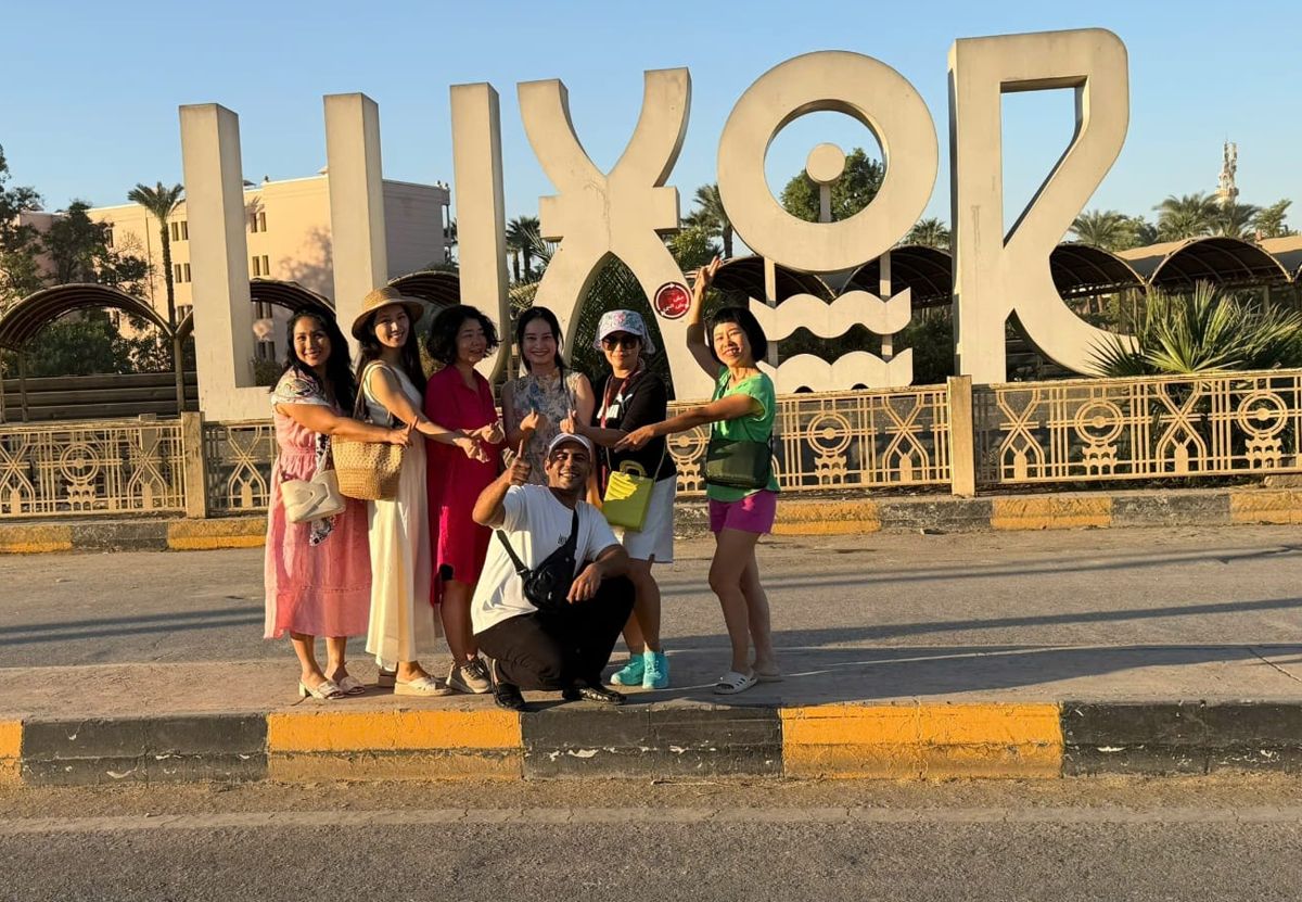 A group of guests at the Luxor sign